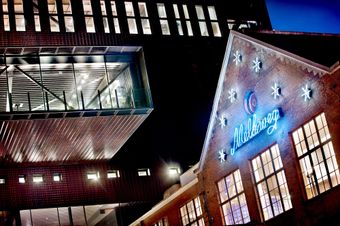 Facade of Melkweg building at night with Melkweg and stars neon signs